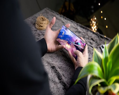Mobile gaming demonstration shown on a central smartphone screen at a technology showcase
